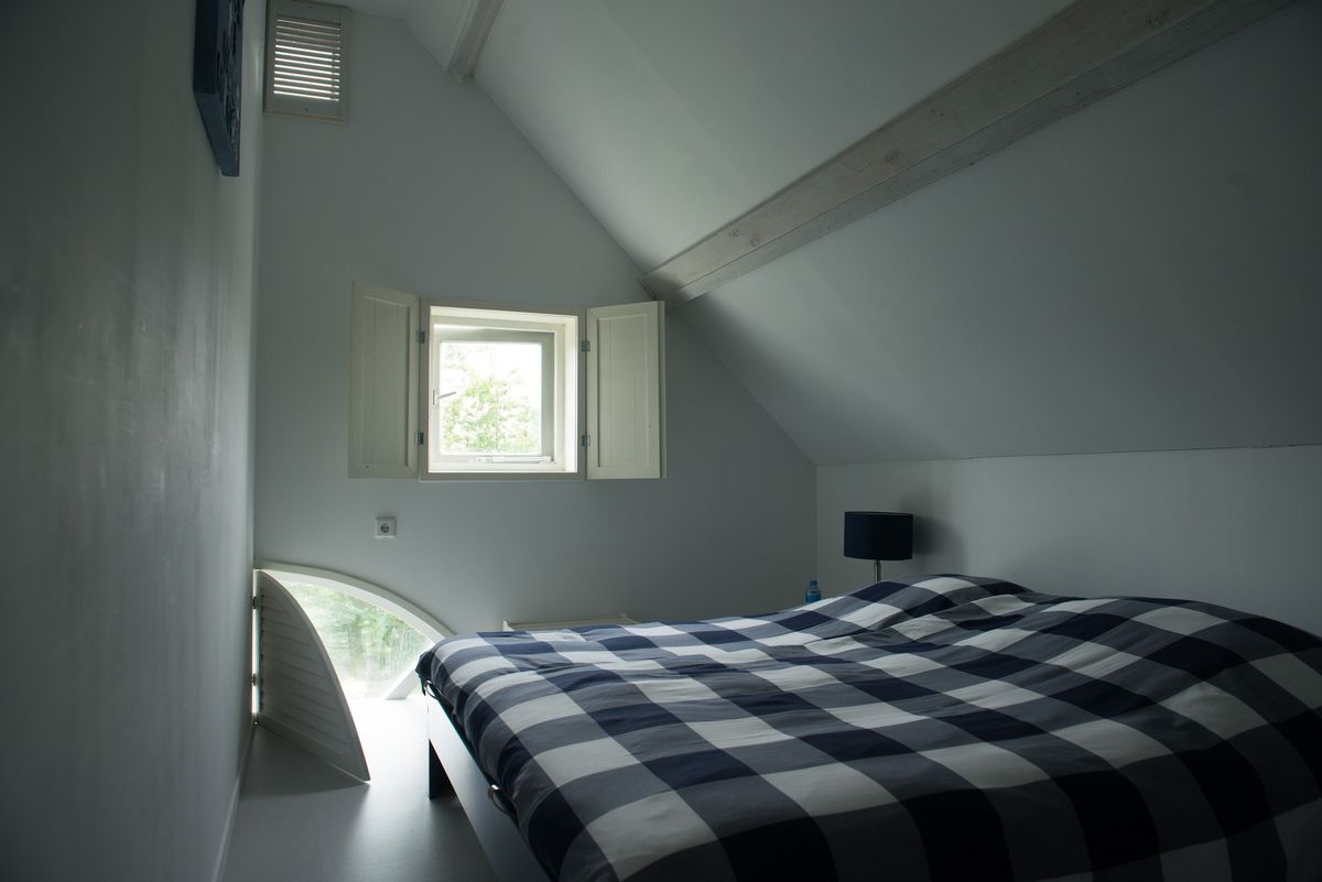 Hoofdslaapkamer met tweepersoonsbed en schuin plafond – Zeeuwshuisje vakantiewoning, Koudekerke